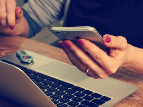 My PA Online virtual assistant UK business support image of a secretary typing whilst on the telephone.